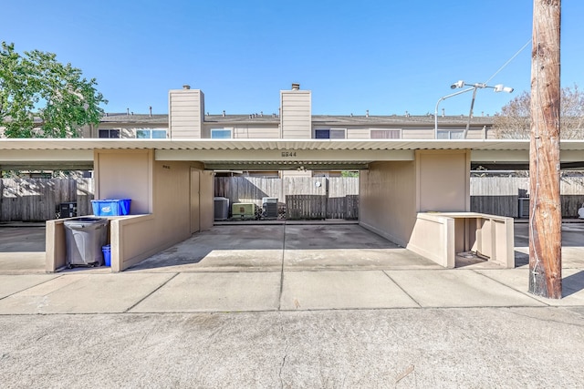 rear view of property with a carport and central air condition unit