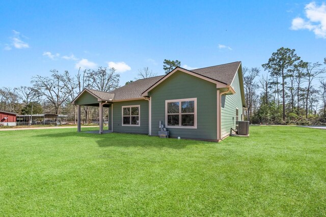 back of property featuring a lawn and central air condition unit