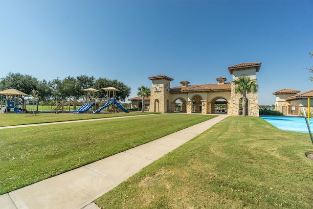 view of property's community featuring a lawn and a playground