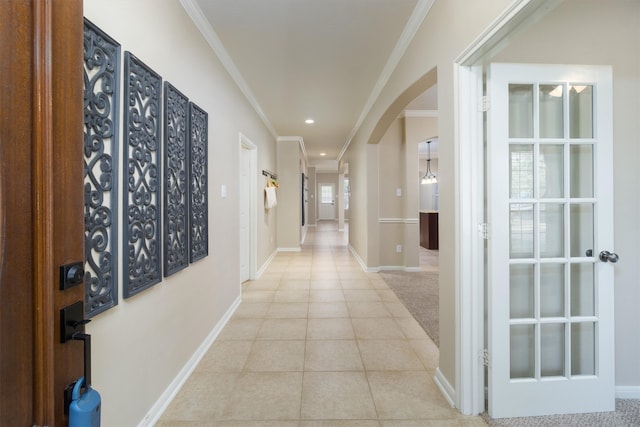 hall with crown molding and light tile patterned floors