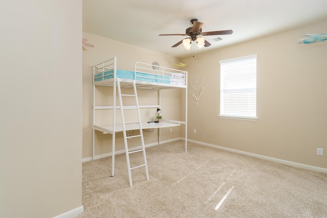 unfurnished bedroom featuring ceiling fan and light carpet