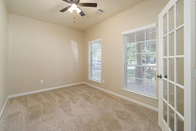 spare room featuring carpet flooring, french doors, and ceiling fan