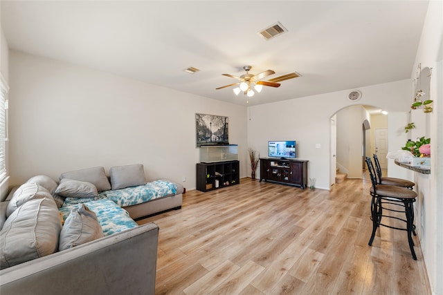 living room with light hardwood / wood-style flooring and ceiling fan