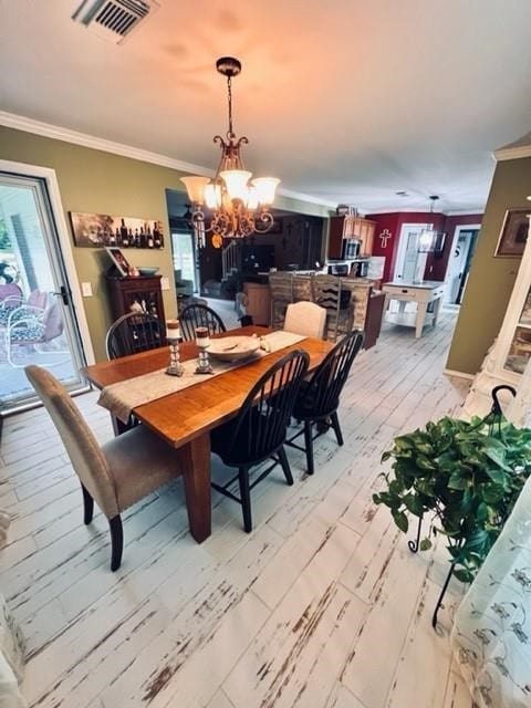 dining area with light wood-type flooring, crown molding, billiards, and an inviting chandelier