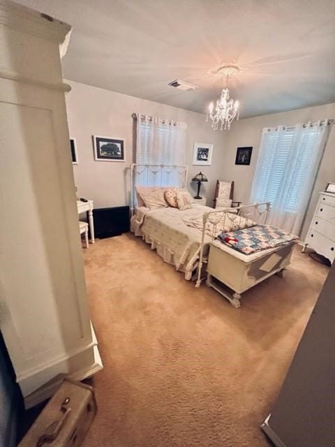 bedroom featuring a notable chandelier and light carpet