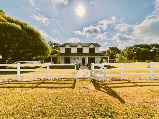 view of front of property with a front yard and a rural view