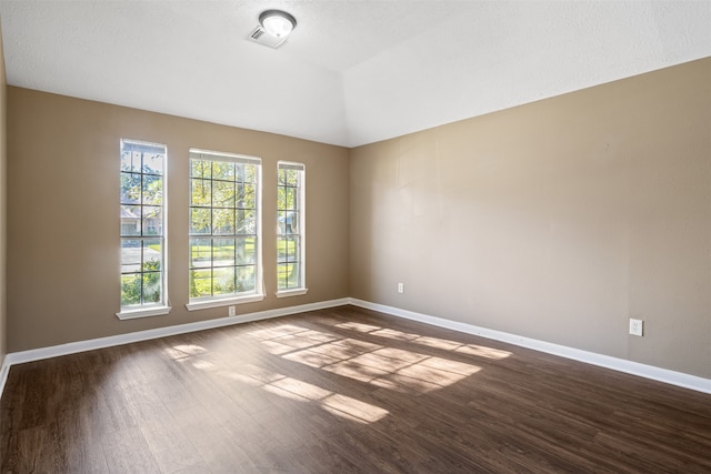 empty room featuring dark hardwood / wood-style floors and vaulted ceiling