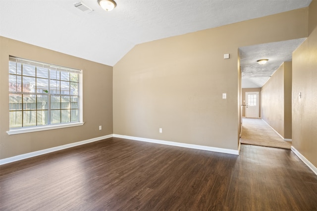 empty room with dark hardwood / wood-style floors, plenty of natural light, and lofted ceiling