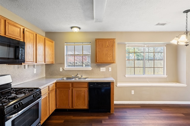 kitchen with black appliances, dark hardwood / wood-style floors, a healthy amount of sunlight, and sink