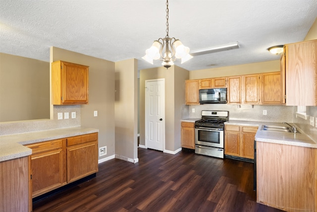 kitchen with gas range, sink, decorative light fixtures, a chandelier, and dark hardwood / wood-style floors