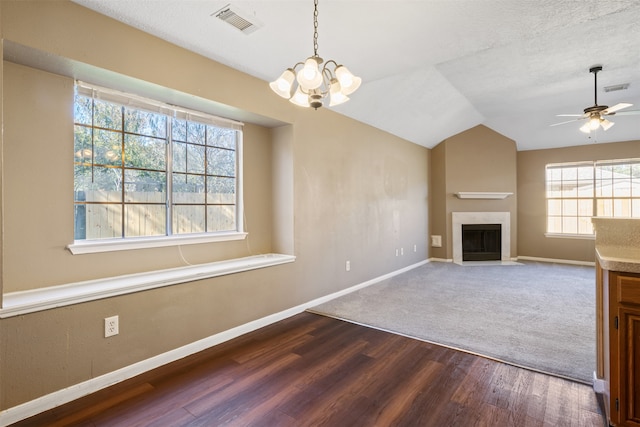 unfurnished living room with ceiling fan with notable chandelier, wood-type flooring, a textured ceiling, and vaulted ceiling