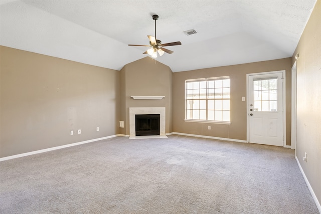 unfurnished living room with light carpet, a textured ceiling, vaulted ceiling, and ceiling fan