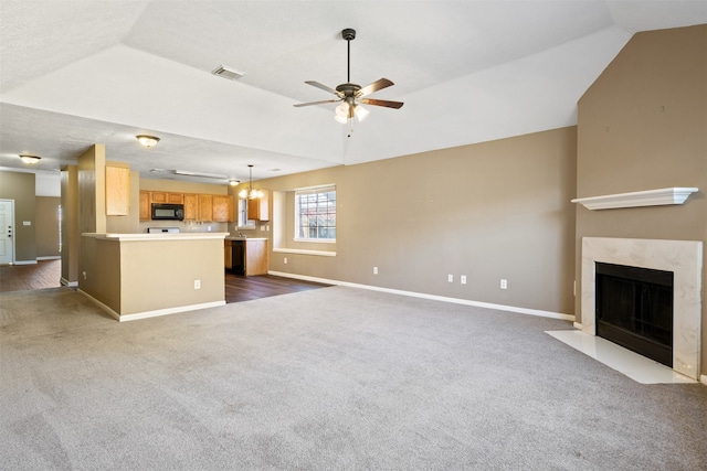 unfurnished living room with lofted ceiling, ceiling fan, dark wood-type flooring, and a premium fireplace