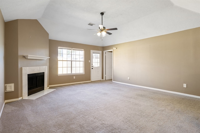 unfurnished living room featuring a tile fireplace, light carpet, ceiling fan, and lofted ceiling