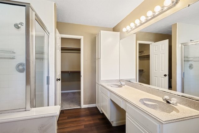 bathroom featuring a textured ceiling, vanity, hardwood / wood-style flooring, and an enclosed shower