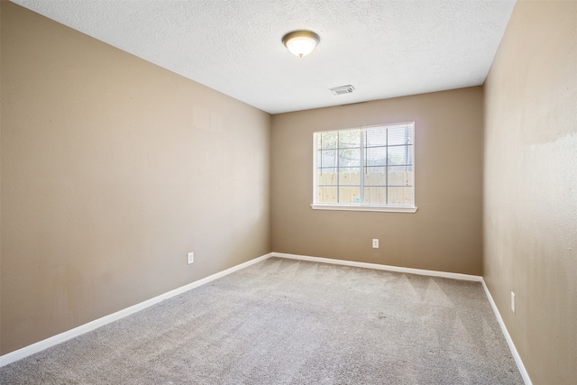 empty room featuring a textured ceiling and carpet floors