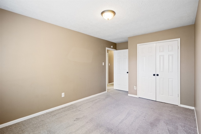 unfurnished bedroom with carpet flooring, a closet, and a textured ceiling