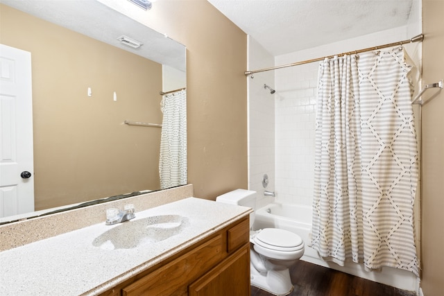 full bathroom featuring vanity, shower / bath combination with curtain, hardwood / wood-style flooring, toilet, and a textured ceiling