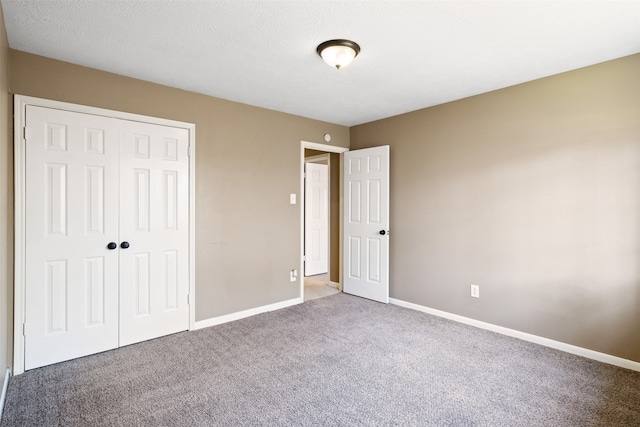 unfurnished bedroom with carpet flooring, a textured ceiling, and a closet