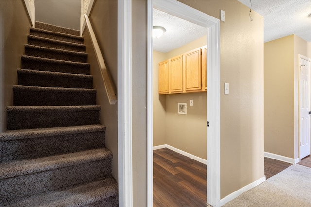 staircase featuring a textured ceiling and hardwood / wood-style flooring