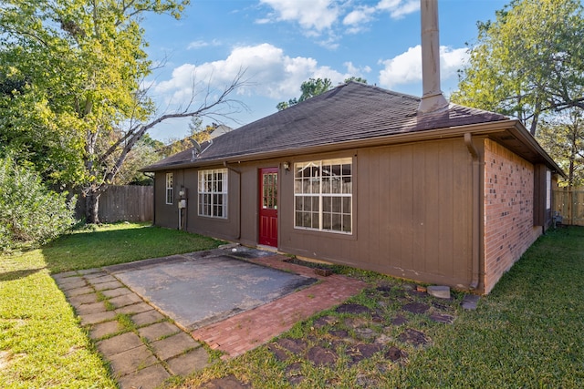 rear view of house with a yard and a patio