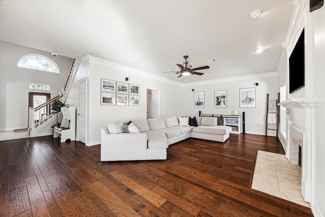 living room featuring a fireplace, dark hardwood / wood-style flooring, ceiling fan, and ornamental molding