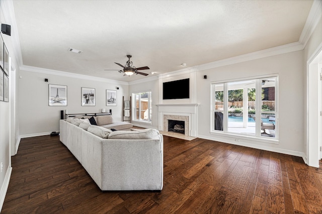 living room featuring ceiling fan, dark hardwood / wood-style flooring, a fireplace, and crown molding