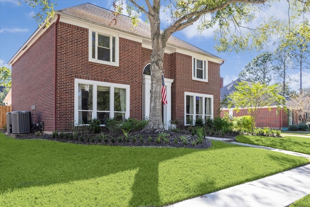 view of front facade featuring cooling unit and a front lawn