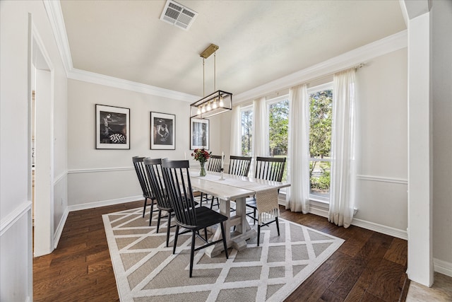 dining room with dark hardwood / wood-style floors, an inviting chandelier, and crown molding