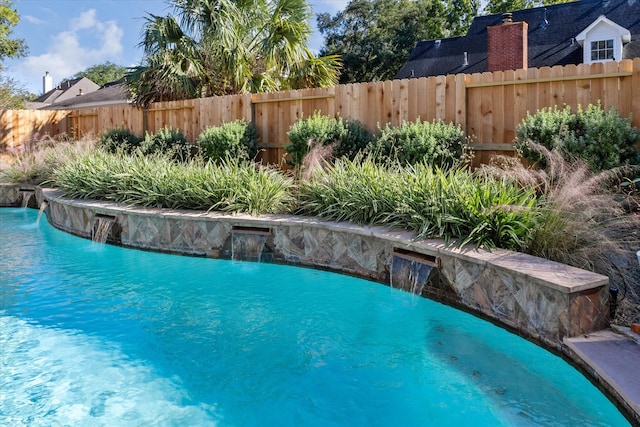 view of swimming pool with pool water feature