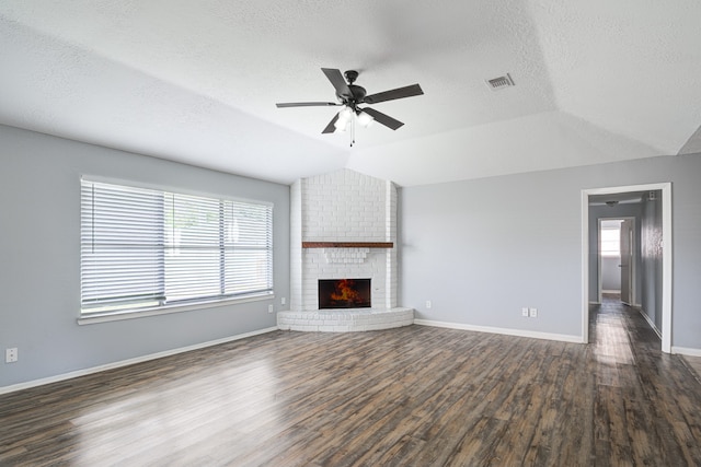 unfurnished living room featuring ceiling fan, dark wood-type flooring, a textured ceiling, lofted ceiling, and a fireplace