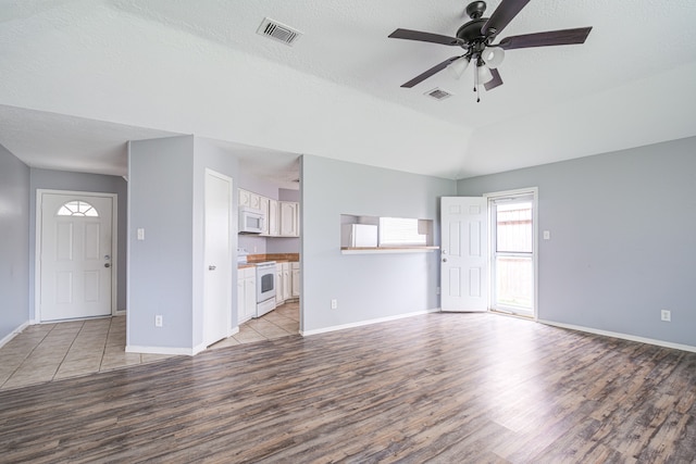 unfurnished living room with a textured ceiling, light hardwood / wood-style flooring, and ceiling fan