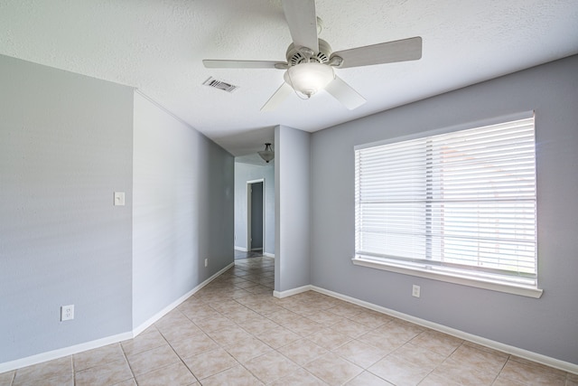 tiled spare room featuring ceiling fan and a textured ceiling