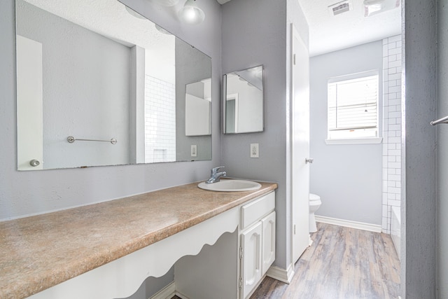 full bathroom with shower / bathing tub combination, wood-type flooring, vanity, and toilet