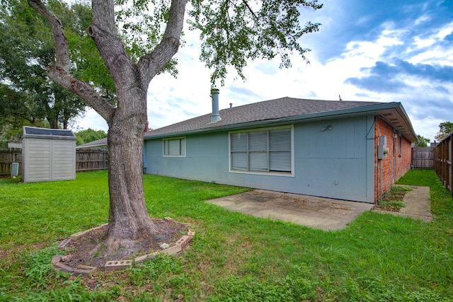 back of property featuring a storage unit and a lawn