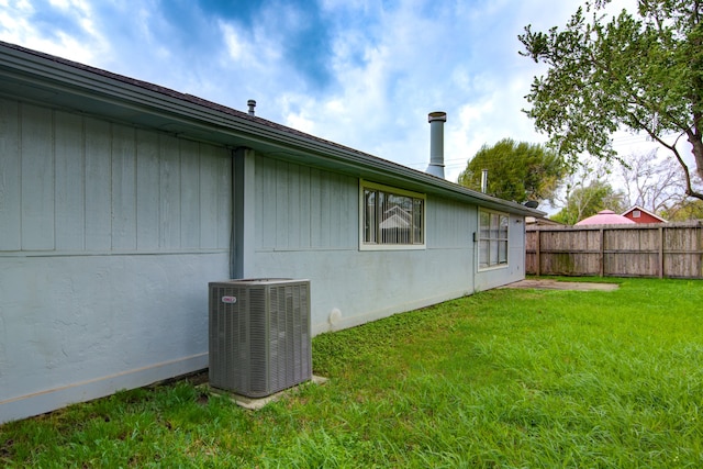 view of home's exterior with a lawn and central AC