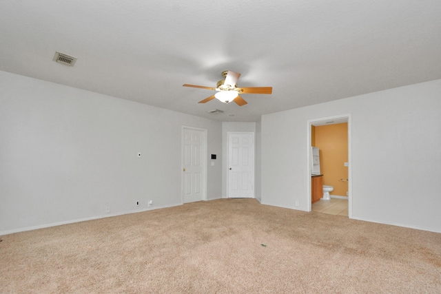 carpeted spare room featuring ceiling fan