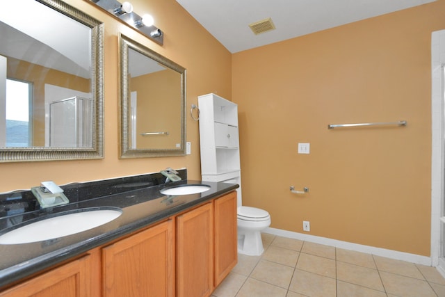 bathroom featuring tile patterned flooring, toilet, an enclosed shower, and vanity