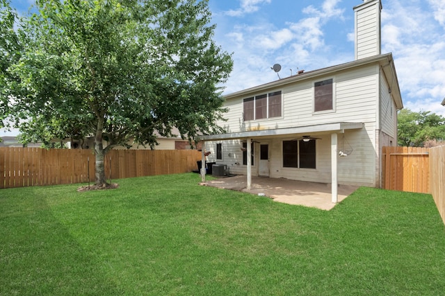 rear view of property featuring ceiling fan, a yard, a patio, and central AC unit