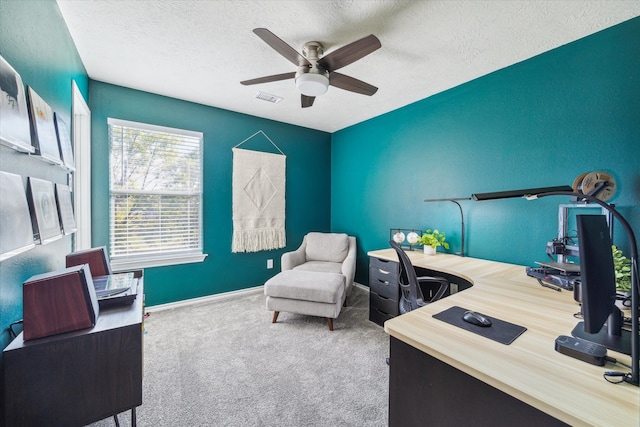 carpeted home office with a ceiling fan, visible vents, a textured ceiling, and baseboards