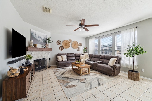 tiled living room with ceiling fan and a textured ceiling