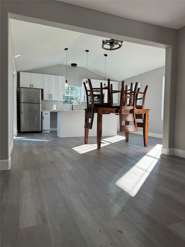 dining space with lofted ceiling and hardwood / wood-style flooring