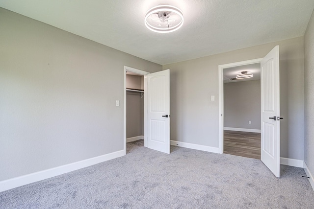 unfurnished bedroom featuring light colored carpet and a closet