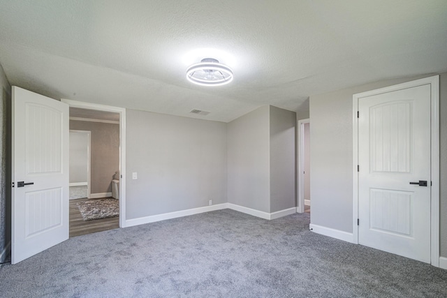 interior space featuring a textured ceiling and carpet flooring