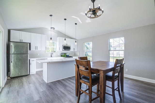 dining area featuring a chandelier, lofted ceiling, dark hardwood / wood-style floors, and sink