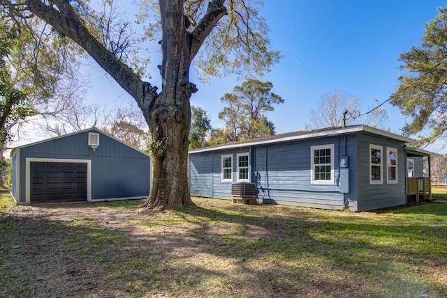 back of house with an outbuilding, a lawn, and a garage