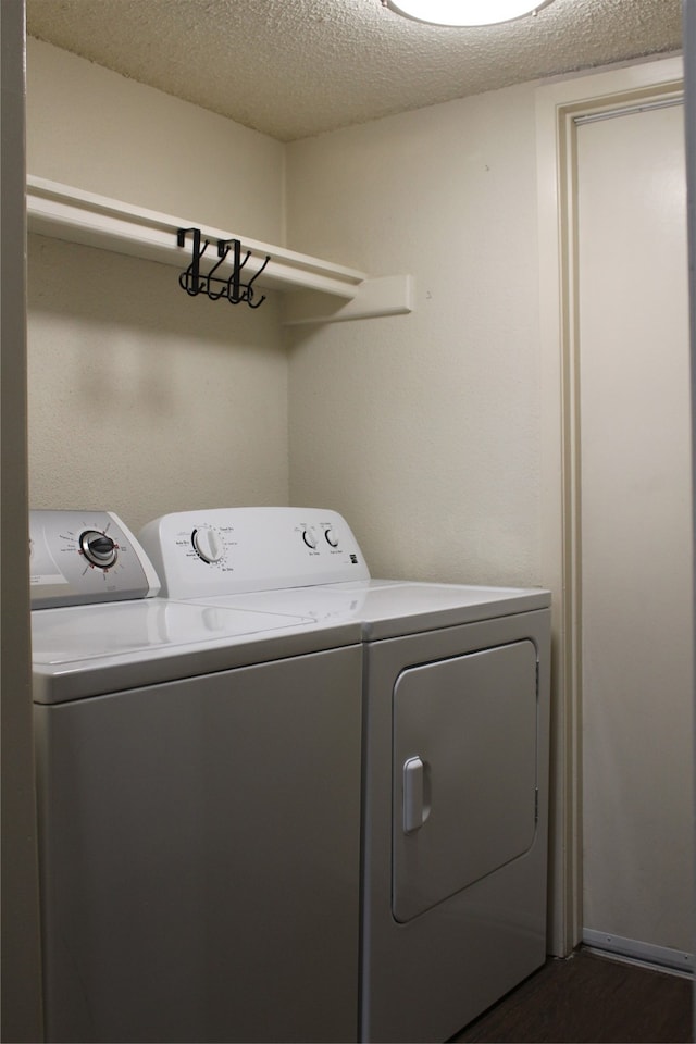 clothes washing area featuring a textured ceiling and washer and clothes dryer