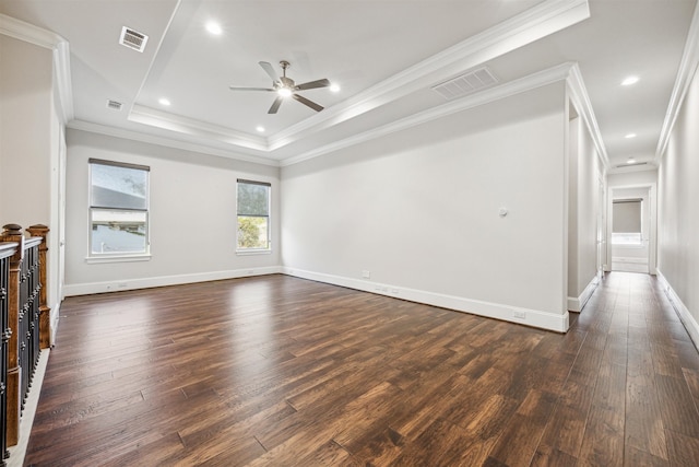 unfurnished living room featuring dark hardwood / wood-style floors, a tray ceiling, ornamental molding, and ceiling fan