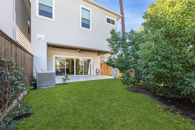 back of house featuring a yard, central AC, and a patio area