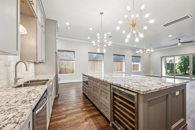 kitchen with decorative backsplash, dark hardwood / wood-style flooring, ceiling fan with notable chandelier, a spacious island, and wine cooler